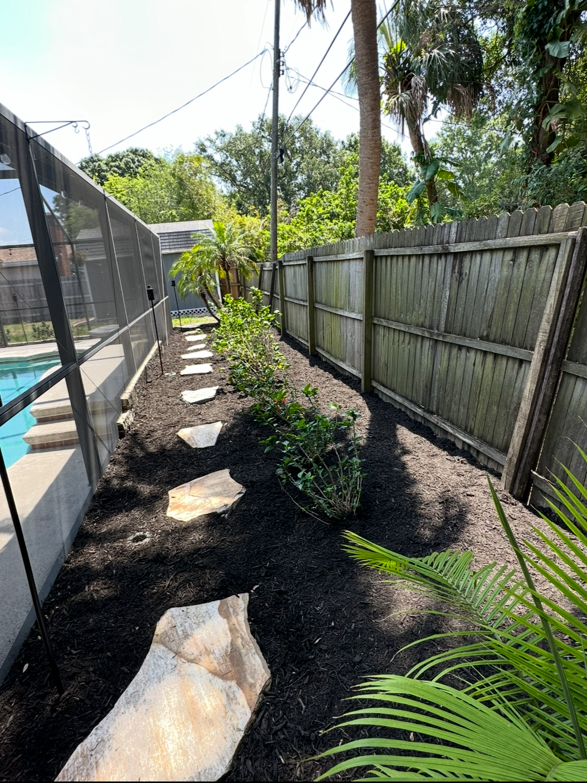 Natural stone and black mulch landscaping by Randoms Lawn Care